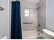 Bathroom featuring accessible grab bar, blue shower curtain, and updated shower at 1719 Belleair Forest Dr # B, Belleair, FL 33756