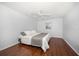 Simple bedroom featuring wood floors, neutral decor, and a comfortable bed at 1719 Belleair Forest Dr # B, Belleair, FL 33756