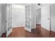 Spacious walk-in closet with rod shelving, wooden floors, and decorative glass doors at 1719 Belleair Forest Dr # B, Belleair, FL 33756