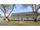 Charming condo featuring a well-maintained exterior, gambrel roof, green door, and manicured landscaping at 1719 Belleair Forest Dr # B, Belleair, FL 33756