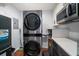 Laundry room with stacked washer and dryer units and storage at 1719 Belleair Forest Dr # B, Belleair, FL 33756