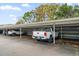Carport parking area with a white pickup truck in parking space at 1719 Belleair Forest Dr # B, Belleair, FL 33756