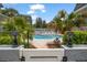 Community pool surrounded by lush landscaping and palm trees, offering a tropical escape at 1719 Belleair Forest Dr # B, Belleair, FL 33756