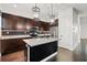 Modern kitchen showcasing an island, granite countertops, dark wood cabinets, and stainless steel appliances at 1910 W North A St # 5, Tampa, FL 33606