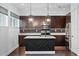 Modern kitchen showcasing an island, granite countertops, dark wood cabinets, and stainless steel appliances at 1910 W North A St # 5, Tampa, FL 33606