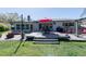 Inviting backyard boasts a patio, wood deck, grill, an outdoor dining set and mature landscaping at 201 79Th Ne Ave, St Petersburg, FL 33702