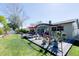 A spacious backyard features a patio, dining set and an outdoor lounging area and mature landscaping at 201 79Th Ne Ave, St Petersburg, FL 33702