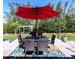 Enjoy the outdoor dining space, complemented by a stylish rug and an eye-catching bright red umbrella at 201 79Th Ne Ave, St Petersburg, FL 33702