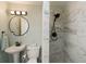 Bathroom featuring modern marble finishes, a round mirror, and stylish lighting at 201 79Th Ne Ave, St Petersburg, FL 33702