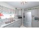 Gray kitchen with stainless steel appliances, tiled backsplash, and plenty of natural light at 201 79Th Ne Ave, St Petersburg, FL 33702