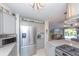 View of kitchen with stainless steel appliances, island with range, and open to living area at 201 79Th Ne Ave, St Petersburg, FL 33702