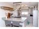 Bright kitchen with gray cabinetry, stainless steel appliances, island, and modern pendant lighting at 201 79Th Ne Ave, St Petersburg, FL 33702