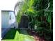 Backyard view of a storage shed surrounded by lush, tropical landscaping on a well-maintained property at 201 79Th Ne Ave, St Petersburg, FL 33702