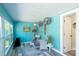 Comfortable sunroom furnished with stylish wicker seating and bright turquoise walls at 201 79Th Ne Ave, St Petersburg, FL 33702