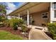 Charming covered front porch with a cozy seating area and lush landscaping, perfect for relaxing outdoors at 2340 W Bay Isle Se Dr, St Petersburg, FL 33705