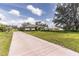 Wide shot of property with a spacious front yard leading up to the well-maintained house at 2355 Mission Valley Blvd, Nokomis, FL 34275