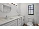 Bright bathroom with dual sinks, quartz countertops, modern fixtures, and a window that allows for natural light at 2710 W Osborne Ave # 1, Tampa, FL 33614