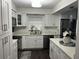 Modern kitchen featuring white cabinetry, stainless steel appliances, stylish countertops and dark wood flooring at 2710 W Osborne Ave # 1, Tampa, FL 33614