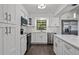 Well-lit kitchen with stainless steel appliances, island with countertop and modern white cabinetry at 2710 W Osborne Ave # 1, Tampa, FL 33614