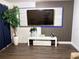 Stylish living room featuring a mounted flat-screen TV, decorative wall and accent lighting on dark wood floors at 2710 W Osborne Ave # 1, Tampa, FL 33614