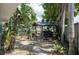 Backyard space with a rustic wooden bar structure, surrounded by tropical foliage, perfect for outdoor entertaining at 300 Westwinds Dr, Palm Harbor, FL 34683