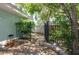 Landscaped backyard featuring a black metal fence with a stone trim and mature trees, offering privacy at 300 Westwinds Dr, Palm Harbor, FL 34683