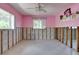 Bedroom with pink walls and a ceiling fan; walls and floors are unfinished at 300 Westwinds Dr, Palm Harbor, FL 34683