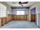 Bedroom with ceiling fan, glass block window, shelf, and unfinished walls and floors at 300 Westwinds Dr, Palm Harbor, FL 34683