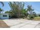 Large driveway with an adjacent house, various trees, and landscaped areas at 300 Westwinds Dr, Palm Harbor, FL 34683