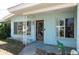 Charming front porch with decorative wood door and mature plantings at 300 Westwinds Dr, Palm Harbor, FL 34683