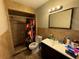 Neutral-toned bathroom featuring tiled walls, a single vanity, a toilet, and a shower with a decorative floral curtain at 3111 W Spruce St, Tampa, FL 33607