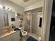 Functional bathroom featuring a shower with a patterned curtain, vanity, mirror, and shelves for storage at 3111 W Spruce St, Tampa, FL 33607