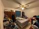 A cluttered bedroom featuring a bed, ceiling fan, wardrobe and shelf at 3111 W Spruce St, Tampa, FL 33607