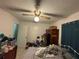 A bedroom featuring tile floors, ceiling fan, double closet, and a window with curtains at 3111 W Spruce St, Tampa, FL 33607