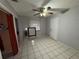 Bedroom featuring tiled floor, a ceiling fan and a closet with peach-colored interior walls and red curtain at 3111 W Spruce St, Tampa, FL 33607