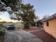 Spacious driveway with partial brick, surrounded by mature trees and grass at 3111 W Spruce St, Tampa, FL 33607