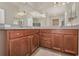 Spacious bathroom featuring a large mirror, dual sinks, and wooden cabinetry for ample storage at 3303 Ranchdale Dr, Plant City, FL 33566