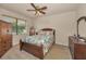 Comfortable bedroom featuring a bed with decorative shell themed bedding, a ceiling fan, and wooden furniture at 3303 Ranchdale Dr, Plant City, FL 33566