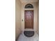 Close-up of a solid front door with an arched transom window in a neutral-colored entryway at 3303 Ranchdale Dr, Plant City, FL 33566