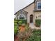 Charming front exterior showcasing stone accents, manicured bushes, and vibrant flowerbeds at 3303 Ranchdale Dr, Plant City, FL 33566