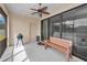 Relaxing screened patio with ceiling fan, comfortable bench, and outdoor grill at 3303 Ranchdale Dr, Plant City, FL 33566