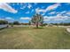 A wide shot showing the expansive green lawn of a property, punctuated by a young tree at 3303 Ranchdale Dr, Plant City, FL 33566