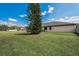Expansive green lawn, framed by a mature tree, showcasing the generous outdoor space of this charming property at 3303 Ranchdale Dr, Plant City, FL 33566