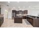 Well-appointed kitchen featuring dark cabinets, a center island, stainless steel appliances, and granite countertops at 3417 Diamond Falls Cir, Land O Lakes, FL 34638