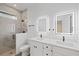 Bathroom featuring a double vanity, walk-in shower with tile surround, and modern fixtures at 3902 E Henry Ave, Tampa, FL 33610