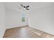 Bright bedroom with wood flooring, a ceiling fan, and a single window at 3902 E Henry Ave, Tampa, FL 33610