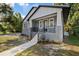 Charming two-story home with a cozy front porch, gray brick accents, and black iron railings at 3902 E Henry Ave, Tampa, FL 33610