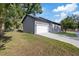 An attached garage and a modern concrete driveway are bordered by a small lawn at 3902 E Henry Ave, Tampa, FL 33610