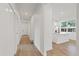 Hallway view of the kitchen and white interior doors, and wood flooring at 3902 E Henry Ave, Tampa, FL 33610