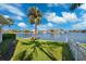 Waterfront backyard featuring lush green grass, a mature palm tree, and views of the adjacent neighborhood at 3906 Versailles Dr, Tampa, FL 33634